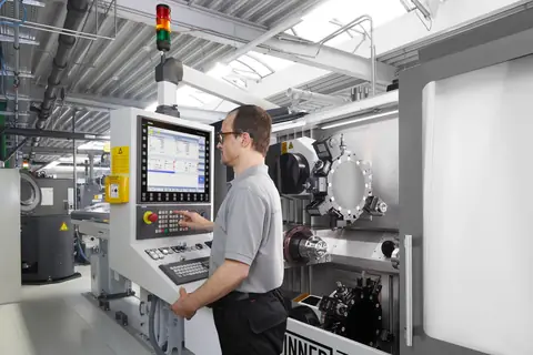 Maschinenbediener an der Steuerung eines CNC-Bearbeitungszentrums