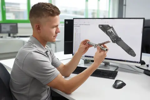 Techniker prüft ein chirurgisches Instrument am CAD-Arbeitsplatz